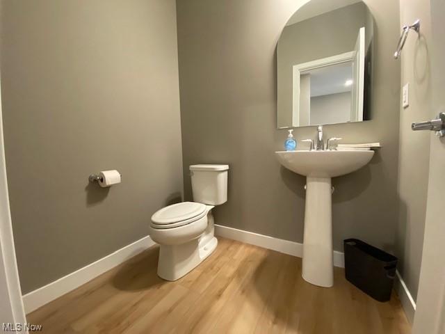 bathroom featuring hardwood / wood-style flooring and toilet