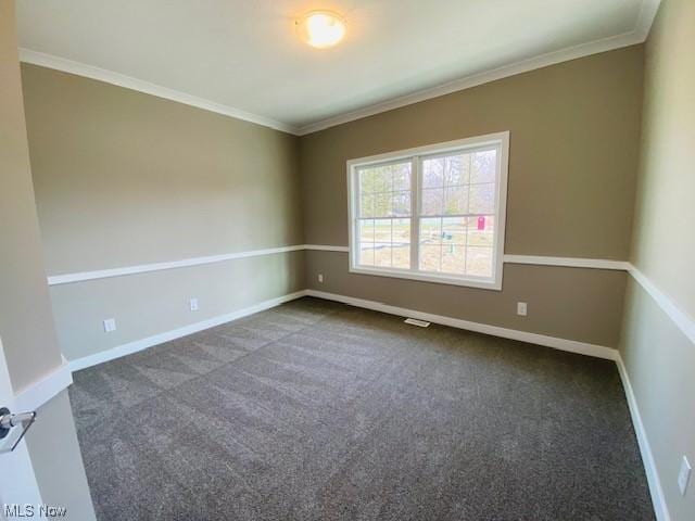 unfurnished room featuring dark carpet and ornamental molding