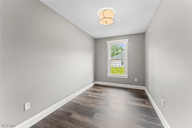 spare room with dark hardwood / wood-style floors