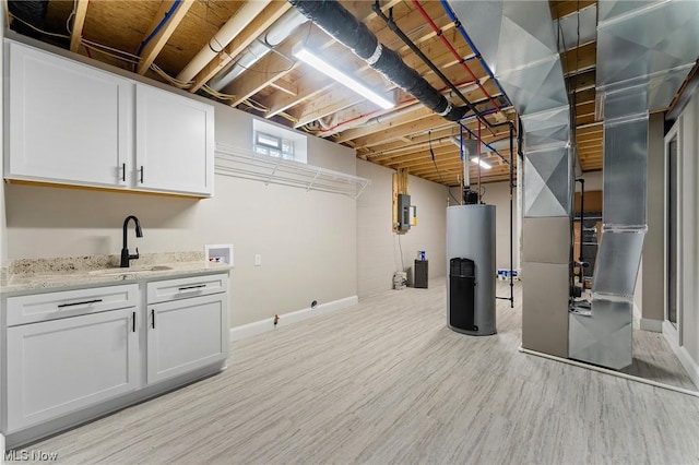 basement featuring light wood-type flooring, sink, and water heater