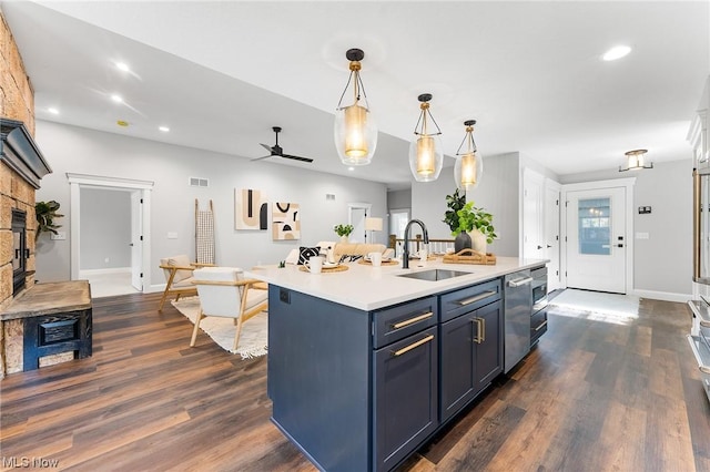 kitchen featuring sink, stainless steel dishwasher, ceiling fan, an island with sink, and decorative light fixtures