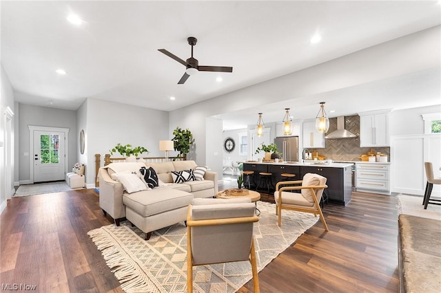 living room with ceiling fan, dark hardwood / wood-style flooring, and sink