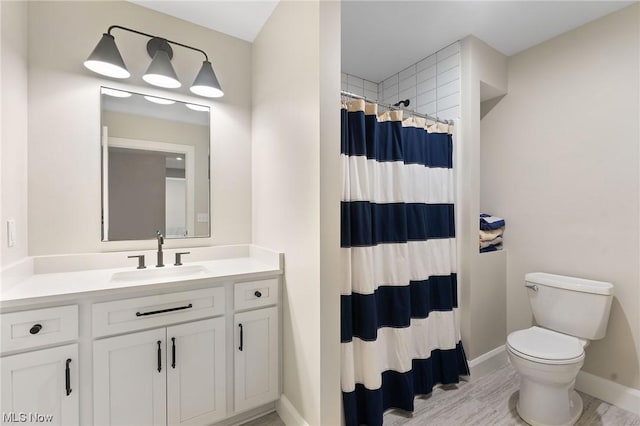 bathroom with walk in shower, vanity, and toilet