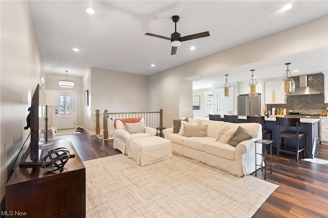 living room featuring a wall mounted air conditioner, dark hardwood / wood-style flooring, and ceiling fan