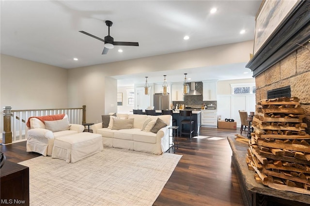 living room featuring ceiling fan and dark hardwood / wood-style flooring