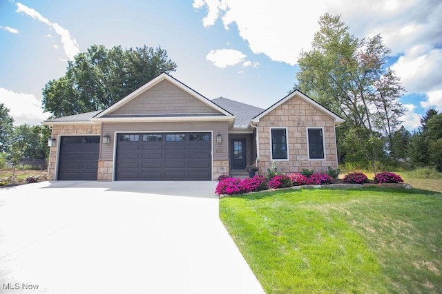 craftsman-style home featuring a garage and a front lawn