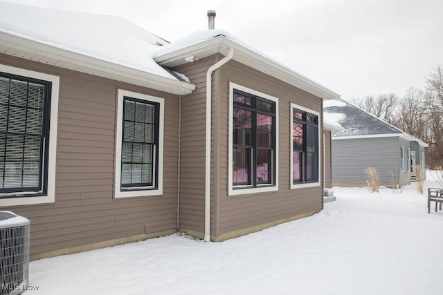 view of snowy exterior with cooling unit