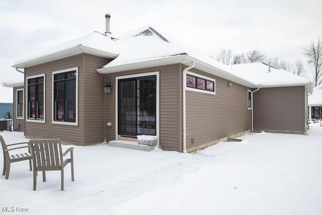 snow covered property with cooling unit