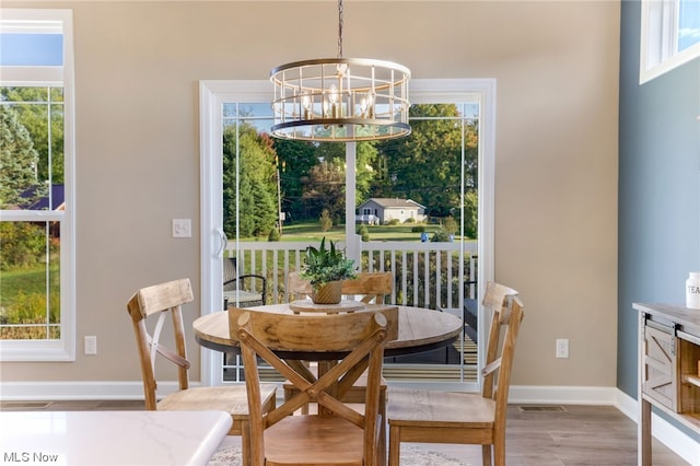 dining area featuring a chandelier, light hardwood / wood-style flooring, and plenty of natural light