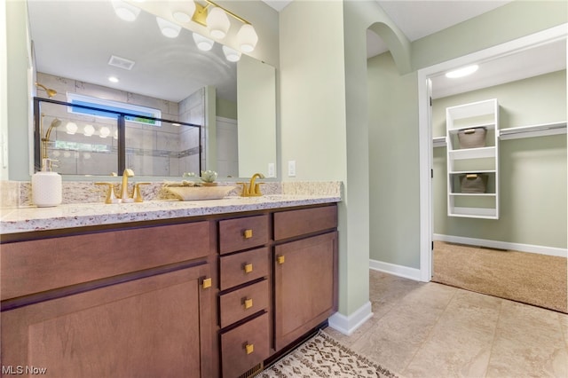 bathroom featuring vanity, tile patterned floors, and a shower with shower door