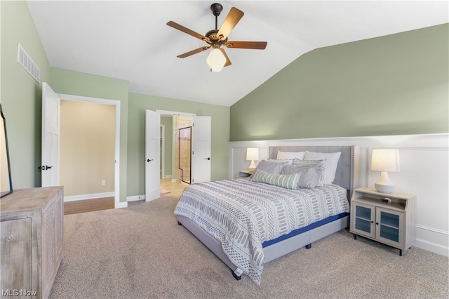 carpeted bedroom with ceiling fan and vaulted ceiling