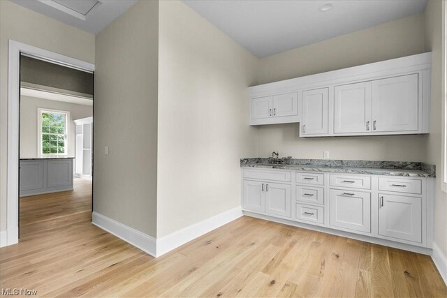 2585 Glendale Rd, Marietta, OH 45750 - kitchen featuring baseboards, light wood-type flooring, light stone counters, white cabinets, and a sink
