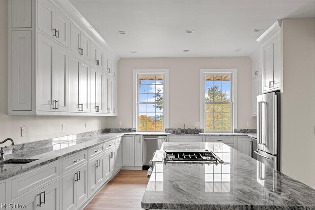2585 Glendale Rd, Marietta, OH 45750 - kitchen featuring a sink, a kitchen island, stainless steel appliances, white cabinets, and light stone countertops