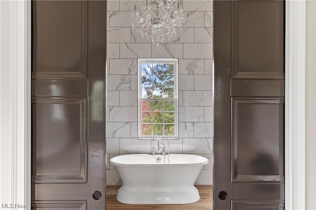 2585 Glendale Rd, Marietta, OH 45750 - bathroom with a soaking tub, tile walls, and an inviting chandelier