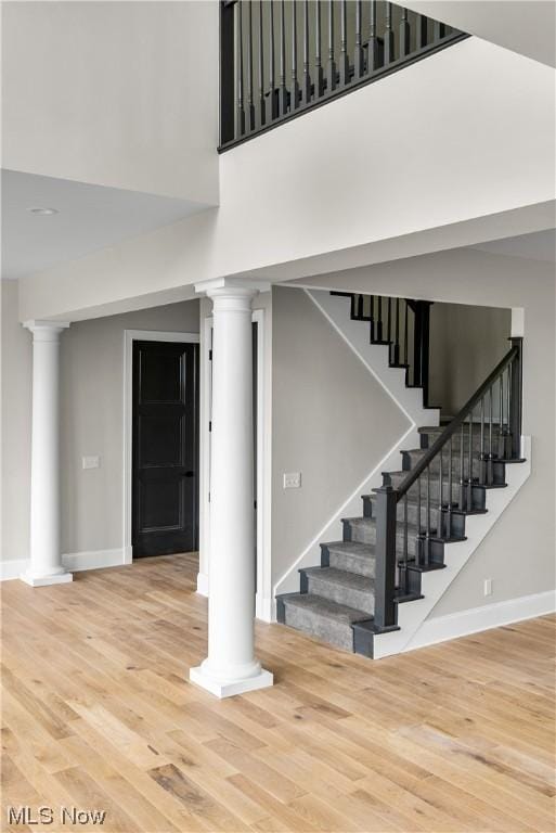 2585 Glendale Rd, Marietta, OH 45750 - stairs with wood finished floors, a high ceiling, baseboards, and decorative columns