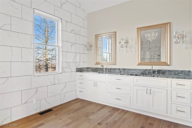 2585 Glendale Rd, Marietta, OH 45750 - full bath with a sink, visible vents, wood finished floors, and double vanity