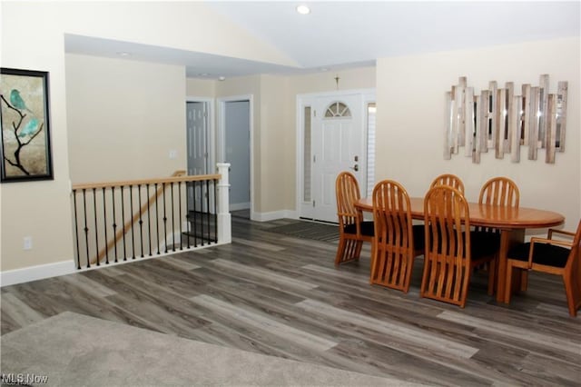 dining space featuring dark hardwood / wood-style flooring and vaulted ceiling