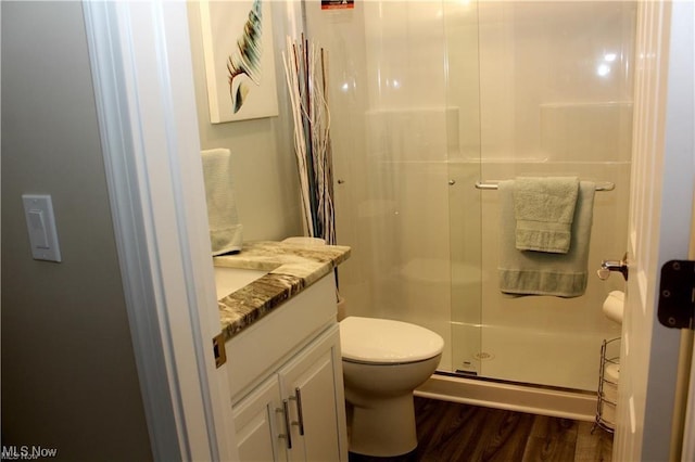 bathroom with vanity, hardwood / wood-style flooring, toilet, and walk in shower