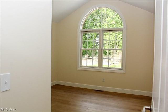 unfurnished room with lofted ceiling and light hardwood / wood-style flooring