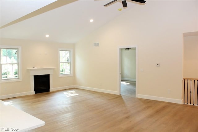 unfurnished living room featuring ceiling fan, high vaulted ceiling, and light wood-type flooring