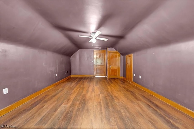 additional living space featuring ceiling fan, dark wood-type flooring, and vaulted ceiling