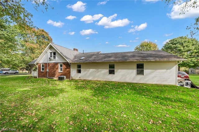 back of house with a lawn and central AC unit