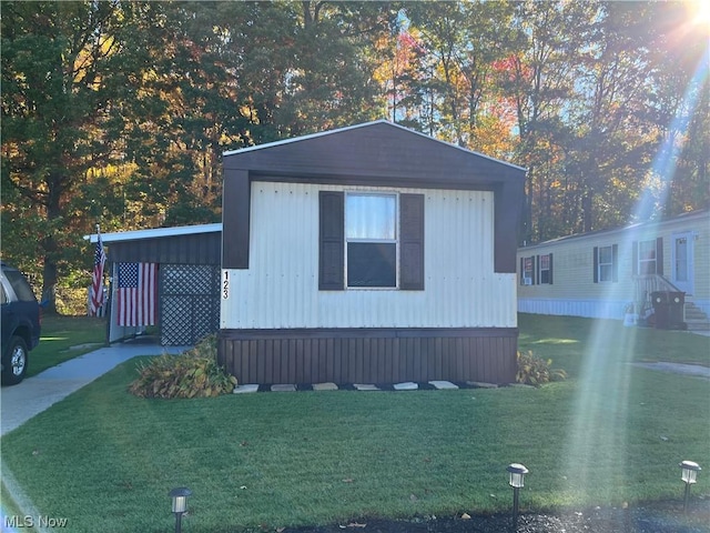 view of front facade featuring a front lawn and an attached carport