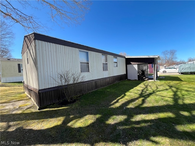 view of side of home with a yard and a carport