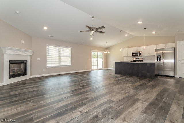 unfurnished living room with dark hardwood / wood-style flooring, high vaulted ceiling, and ceiling fan with notable chandelier