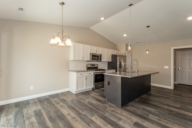 kitchen with pendant lighting, dark hardwood / wood-style flooring, white cabinets, appliances with stainless steel finishes, and a center island with sink