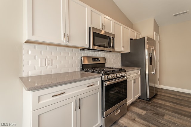 kitchen with dark hardwood / wood-style floors, white cabinets, stainless steel appliances, vaulted ceiling, and light stone countertops