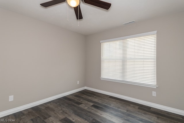 spare room with dark wood-type flooring and ceiling fan