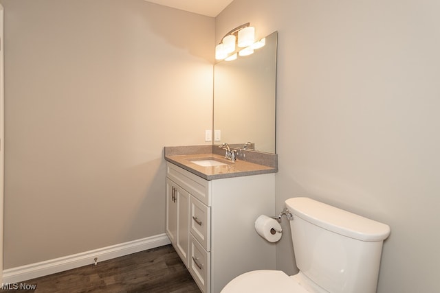 bathroom featuring toilet, vanity, and hardwood / wood-style flooring