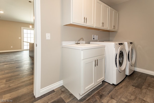 laundry room with washer hookup, sink, dark hardwood / wood-style flooring, washing machine and clothes dryer, and cabinets