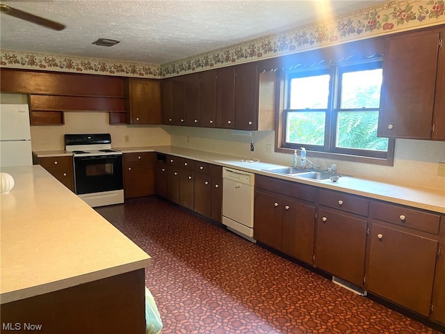 kitchen featuring white appliances, a textured ceiling, ceiling fan, dark brown cabinetry, and sink