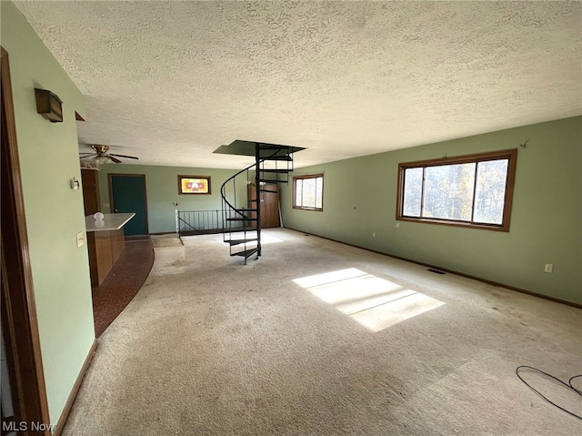 interior space with a textured ceiling and ceiling fan