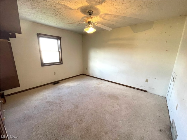 carpeted empty room with a textured ceiling and ceiling fan