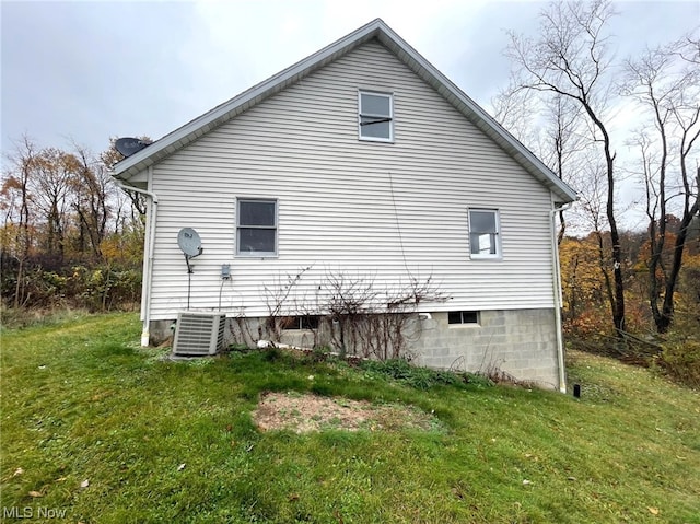 view of home's exterior with cooling unit and a yard