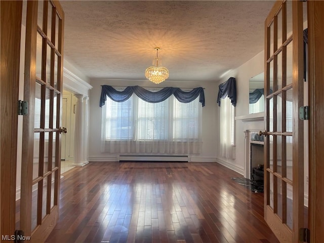 unfurnished dining area featuring an inviting chandelier, french doors, a textured ceiling, a baseboard radiator, and dark hardwood / wood-style flooring