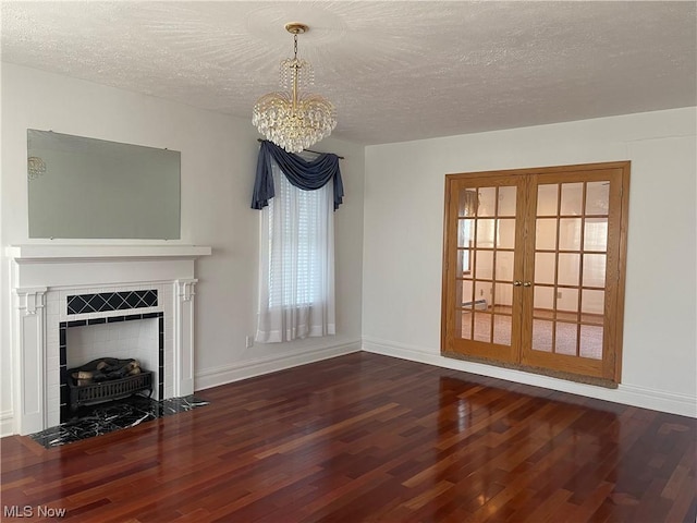 unfurnished living room with a textured ceiling, dark hardwood / wood-style floors, and a notable chandelier