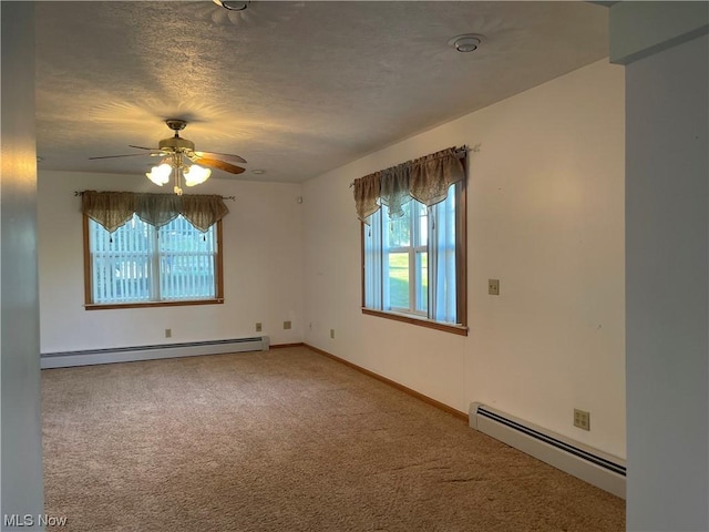 empty room featuring ceiling fan, carpet floors, a textured ceiling, and a baseboard heating unit