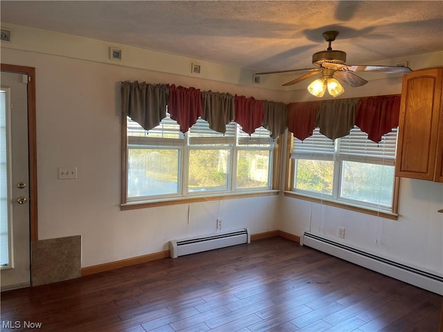 unfurnished dining area featuring ceiling fan, dark hardwood / wood-style flooring, and a baseboard radiator