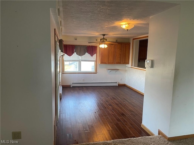 kitchen featuring baseboard heating, ceiling fan, and dark wood-type flooring