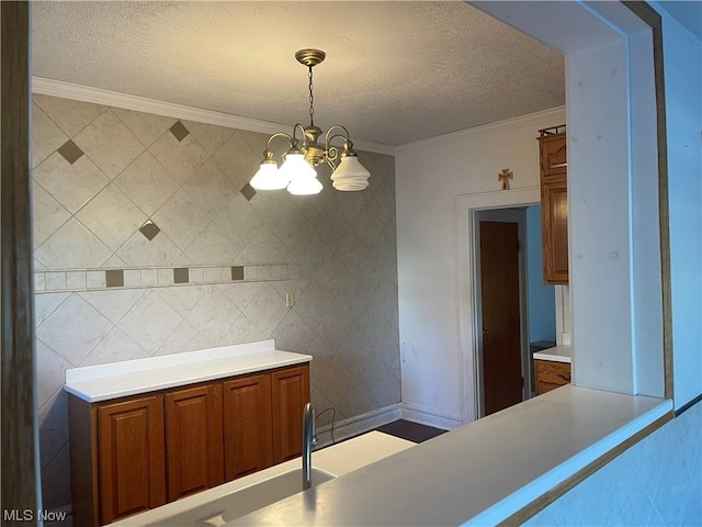 kitchen with pendant lighting, a textured ceiling, an inviting chandelier, and crown molding