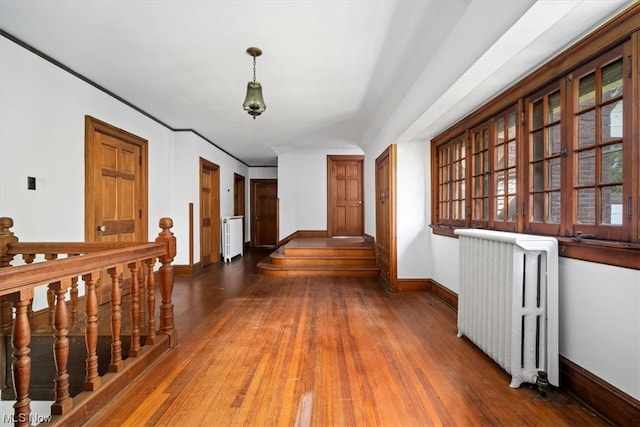 hallway with hardwood / wood-style flooring and radiator heating unit