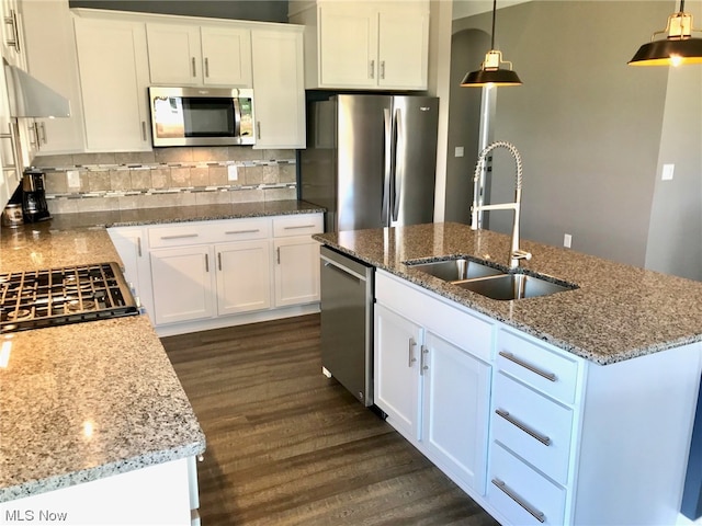 kitchen with stainless steel appliances, dark wood-style flooring, a sink, decorative backsplash, and light stone countertops