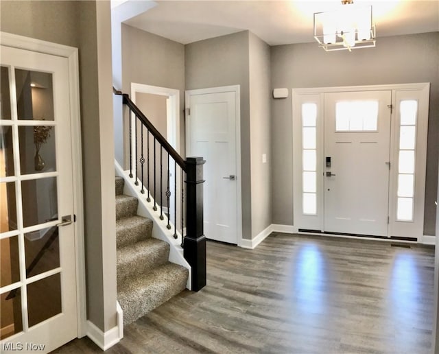 foyer with a notable chandelier and dark wood-type flooring