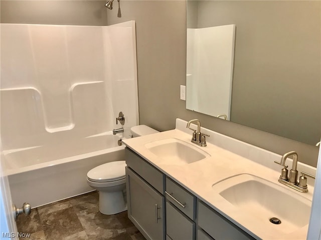 bathroom with double vanity, bathing tub / shower combination, a sink, and toilet