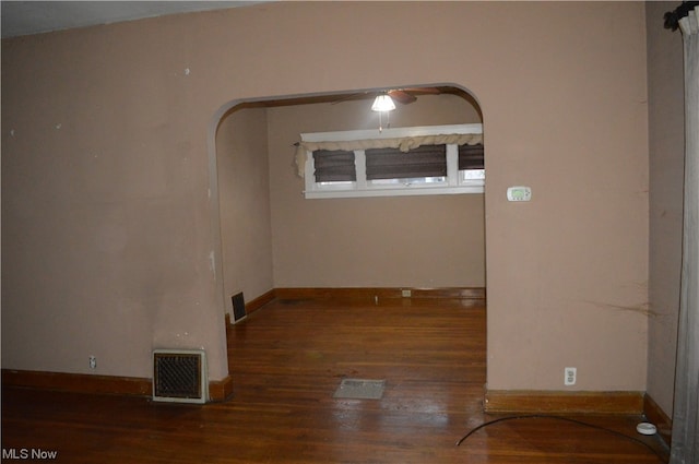 empty room featuring dark wood-type flooring and ceiling fan