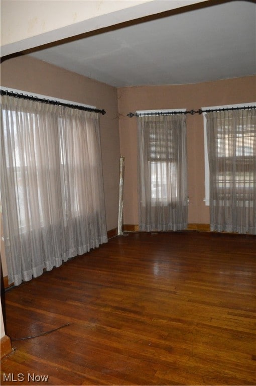 unfurnished room with dark wood-type flooring